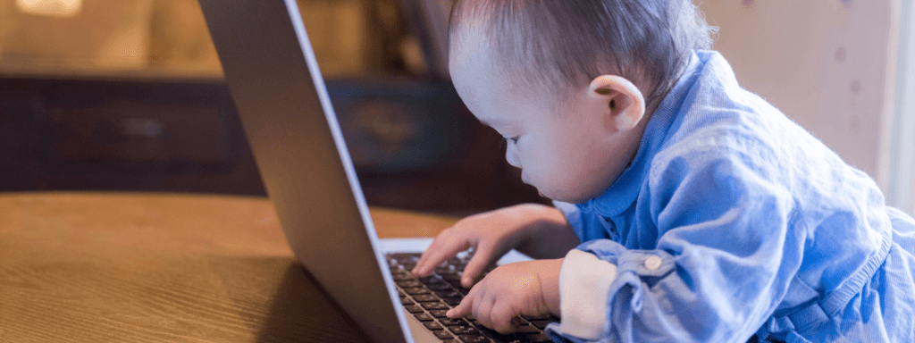 Class providers privacy policy blog: Baby looks focussed as they look down at a laptop