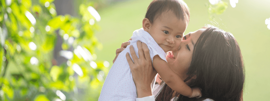 Outdoor baby classes - image shows a mother nuzzling her baby