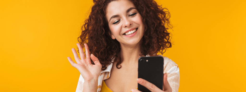 build a newsletter: woman waves at her phone