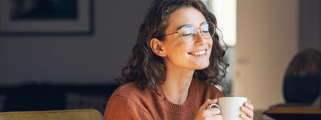 write a blog - image shows a woman smiling and holding a cup of tea